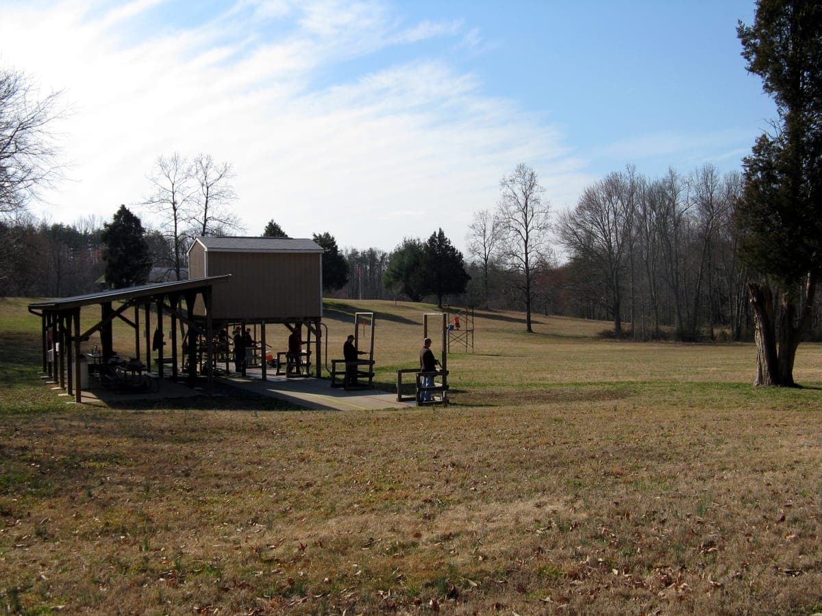 Trap shooting station with clay target launcher